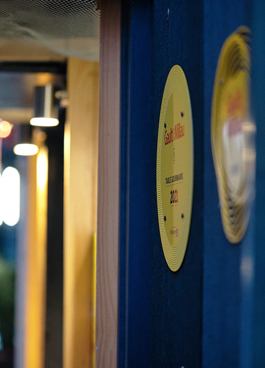 Façade d'un restaurant gastronomique intime à Paris le soir